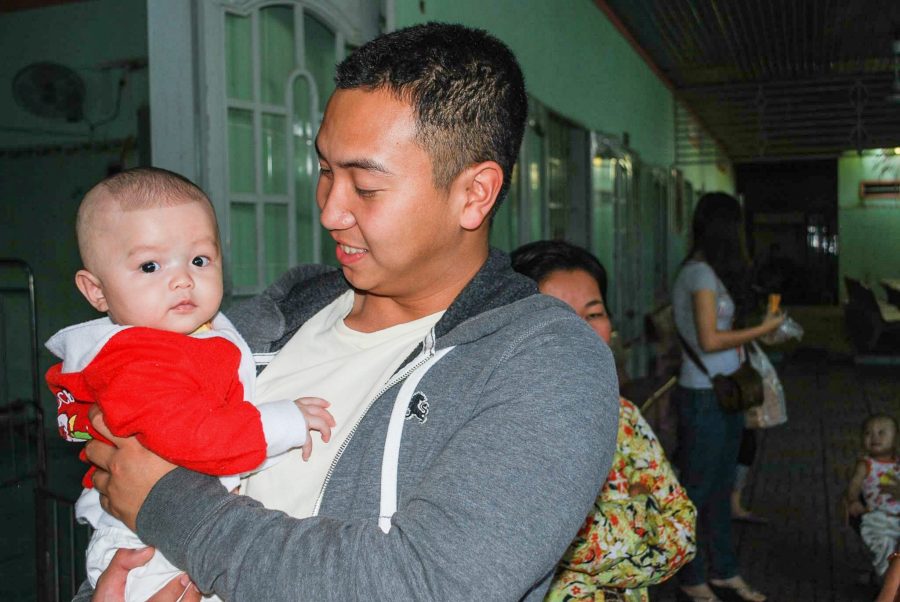 Quinn Bui, owner of Nine Promotions, is shown carrying a baby when visiting an orphanage in Vietnam in 2012. (Nine Promotions)