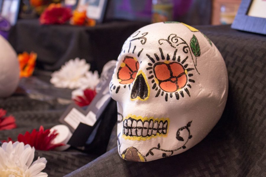 A colorfully decorated skull lays atop an altar in El Centro inside the Lory Student Center. The altar was set up in celebration of Dia De Los Muertos, meaning Day of the Dead in English. The Mexican holiday begins October 31st and lasts until November 2nd, where it is believed that the spirits of those who have passed away are able to revisit their families and friends. (Brooke Buchan | Collegian) 