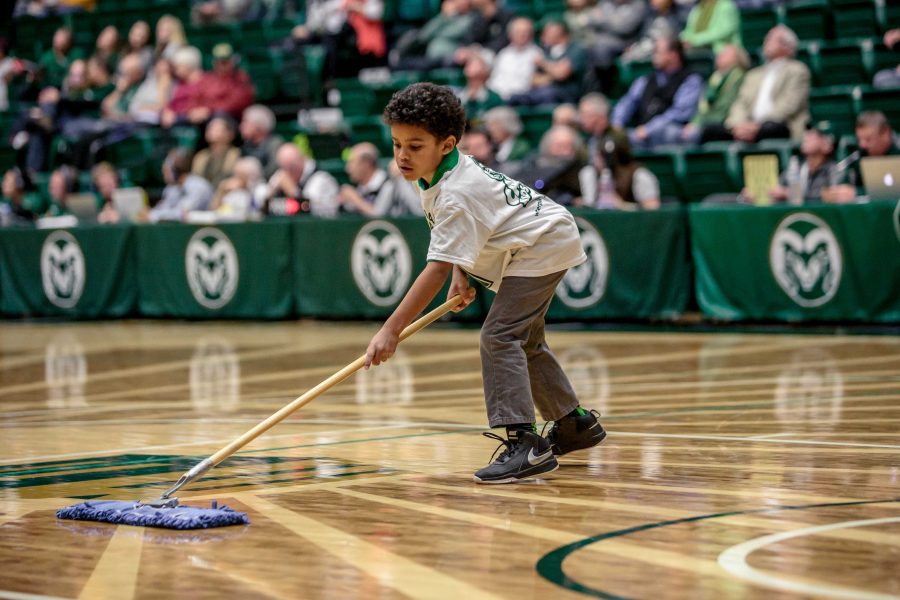 Seven year old Judah Skinner cleans the Moby Arena court of dust during a timeout for the mens basketball team. Cams Kids Club allows children 12 and under access to basketball and volleyball games in addition to other exclusive events. (Davis Bonner | Collegian)