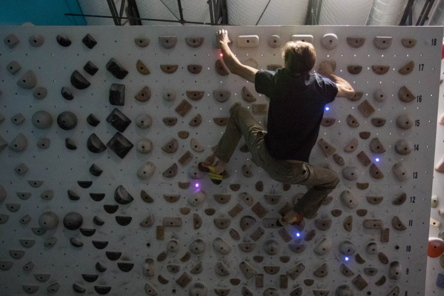 Adrian Zdrobis, a rock climber of 25 years, tries out the rock climbing wall guided with lasers. The lasers determine which grips can be used, with the different colors denoting different things.With a duplicate rock wall around the world, there are an infinite combination of laser patterns that the climber can try, and patterns can be created and shared through an app. (Julia Trowbridge | Collegian)