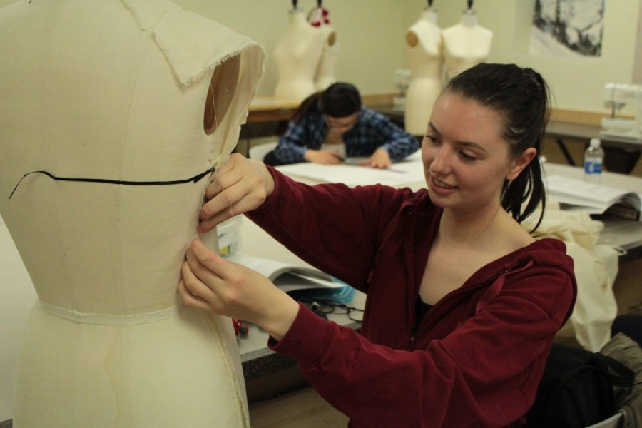 Eva O'Donovan, pictured here in the beginning stages of her project, measures the mannequin so she can adjust her dress design. (Sarah Ehrlich | Collegian)