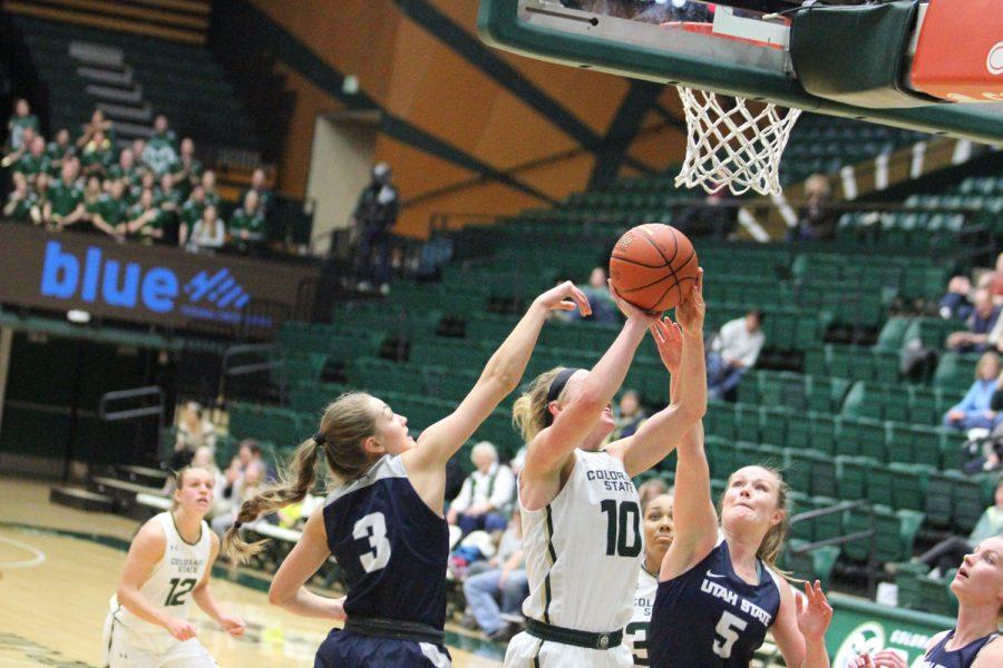 Senior Hannah Tvrdy takes a basket against two Utah State defenders at the game Wednesday evening. Rams took the win 56 to 45. Photo by Olive Ancell | Collegian