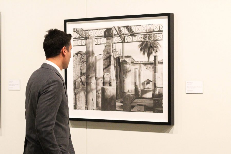 A guest looks at one of the large scale prints in William Wylies Pompeii Archive exhibit in the Gregory Allicar Museum of Art in the UCA during the Visualize fundraiser. Wylie, who got his BFA at CSU, explores the contemporary state of the archeological site using large-format black and white photographs. (Ashley Potts | Collegian)