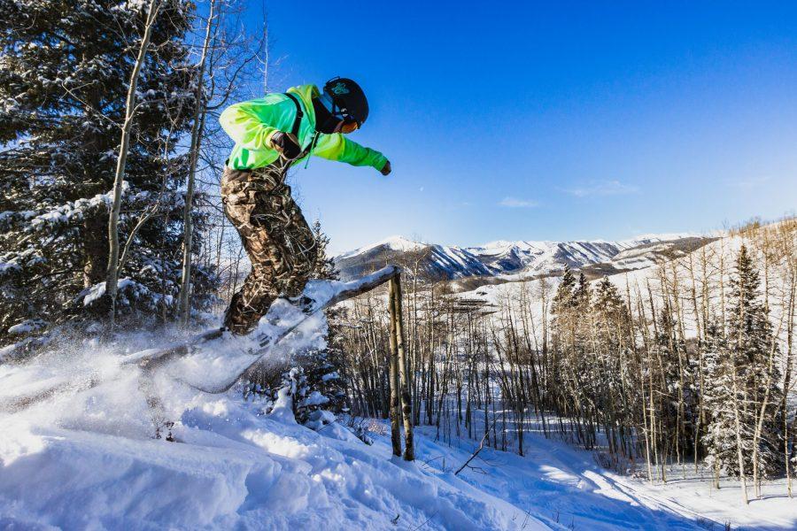 Austin Burke rides over a wooden rail while snowboarding at Crested Butte, Colorado. (Jack Starebaum | Collegian)