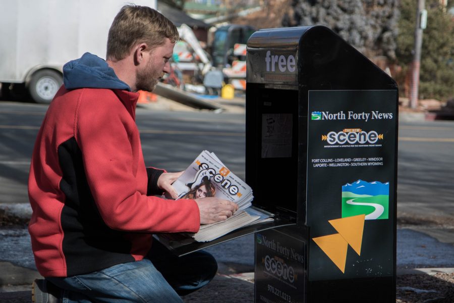 Blaine Howerton, Colorado State University alumna and publisher for North Forty News and The New Scene, stocks a news stand with both publications. Both publications are two out of four publications in the Northern Colorado area that are over 25 years old. (Julia Trowbridge | Collegian)