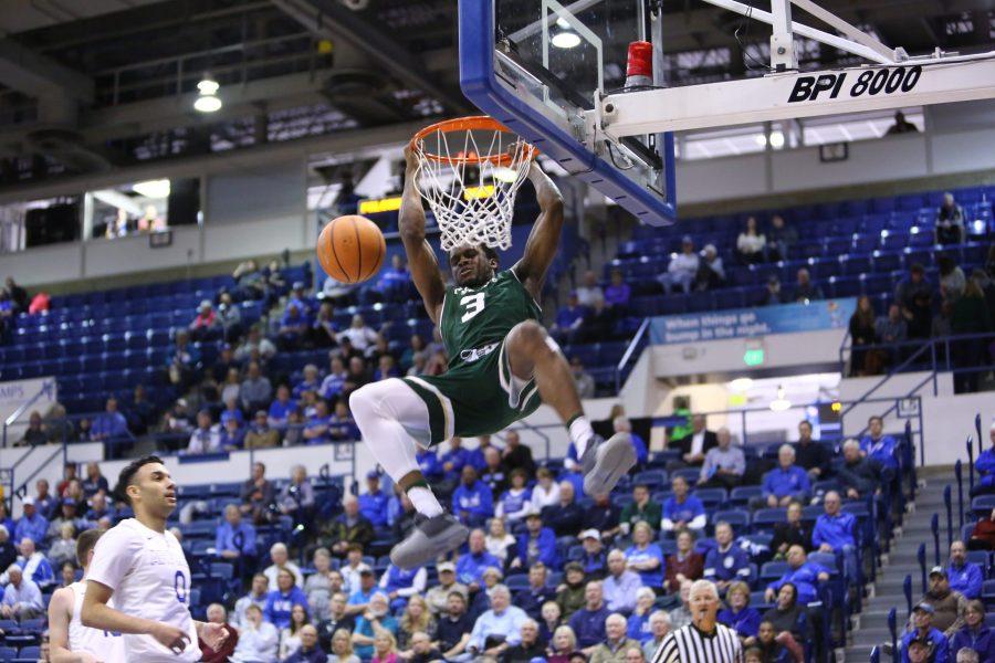 Colorado State University sophomore guard Raquan Mitchell hangs on the rim after dunking against Air Force on Tuesday, Feb. 6. (Davis Bonner | Collegian)