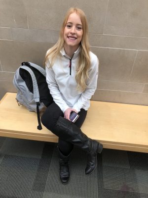 A student with a backpack sits on a bench in the Behavioral Sciences Building at Colorado State University