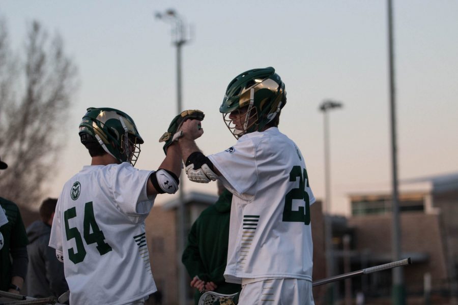 Connor Bergmann, freshmen, fist bumps Grant Breeden after coming off the field during the thrid quarter. CSU lost to Cal Poly with a score of 9-7.  (Julia Bailey | Collegian)