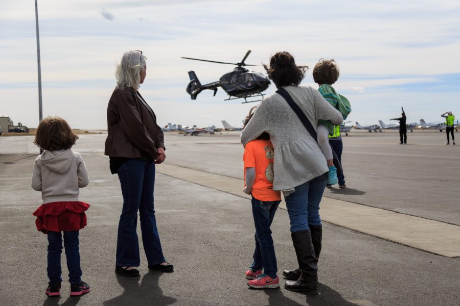 Participants of the Women Of Aviation Worldwide Week watch as volunteer pilot Dianna Stangers EC135 takes off from Northern Colorado Regional Airport with another group. The 2018 WOAW event provided over 1,700 flights to women of all ages.(Davis Bonner | Collegian)