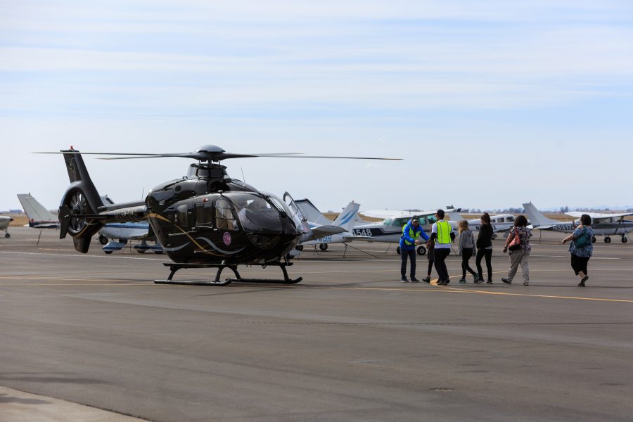 Participants of the Women Of Aviation Worldwide Week prepare to board volunteer pilot Dianna Stangers EC135 at the Northern Colorado Regional Airport. The 2018 WOAW event provided over 1,700 flights to women of all ages.(Davis Bonner | Collegian)