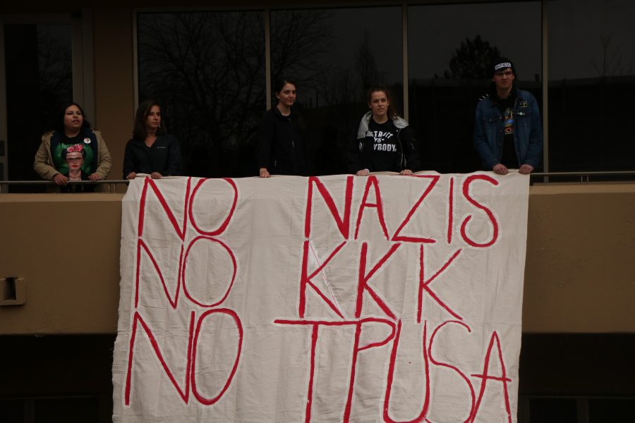 Students stand holding a banner chanting during the CSUnite march