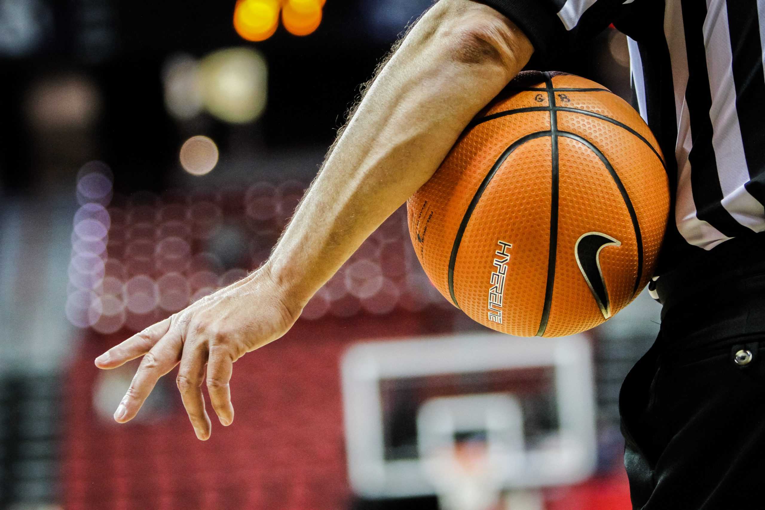 man holds basketball in arms