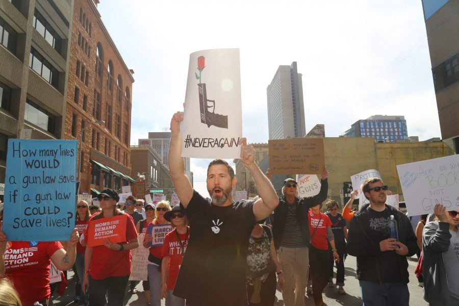 Tony Felice leads participants in the March for Our Lives in a chant demanding gun control as they continue through the streets of Denver Saturday afternoon. (Davis Bonner | Collegian)