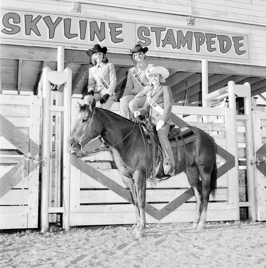 The 1967 College Days Rodeo Queen is seated on a horse. Two attendants are seated on the fence behind her. (Photo courtesy of University Historic Photograph Collection)
