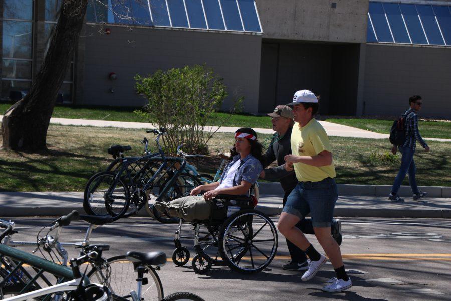 Brette "Arnie" Arnusch as he is pushed by fellow Alpha Gamma Rho members. (Devin Cornelius | Collegian)