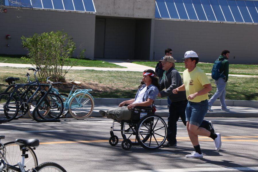Brette "Arnie" Arnusch as he is pushed by fellow Alpha Gamma Rho members. (Devin Cornelius | Collegian)