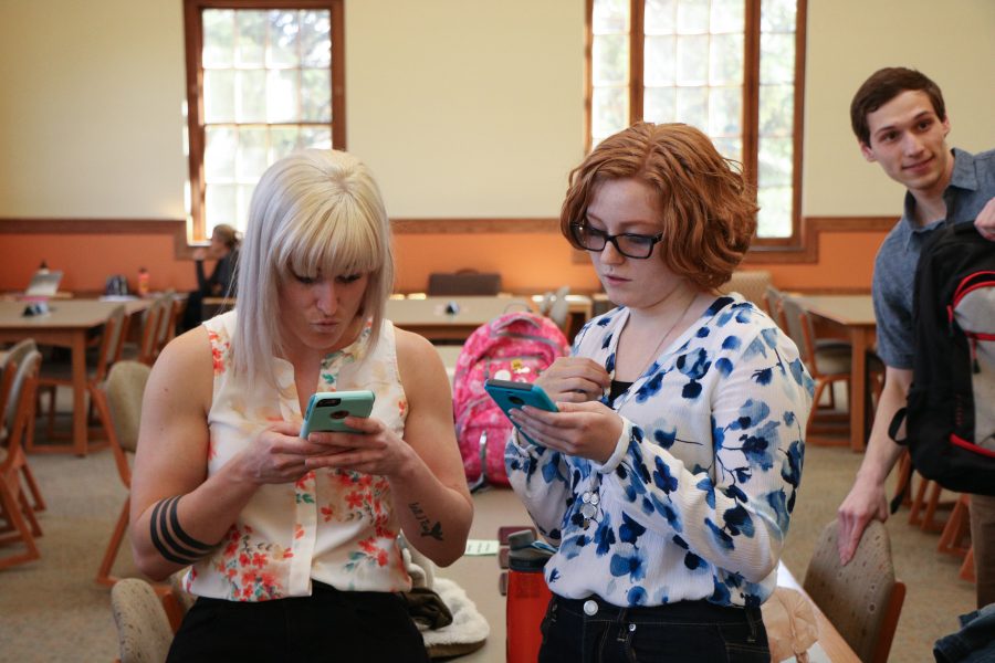 Destiny Burnsworth and Ashley VanDyke check their phones at the congratulatory party. (Devin Cornelius | Collegian)