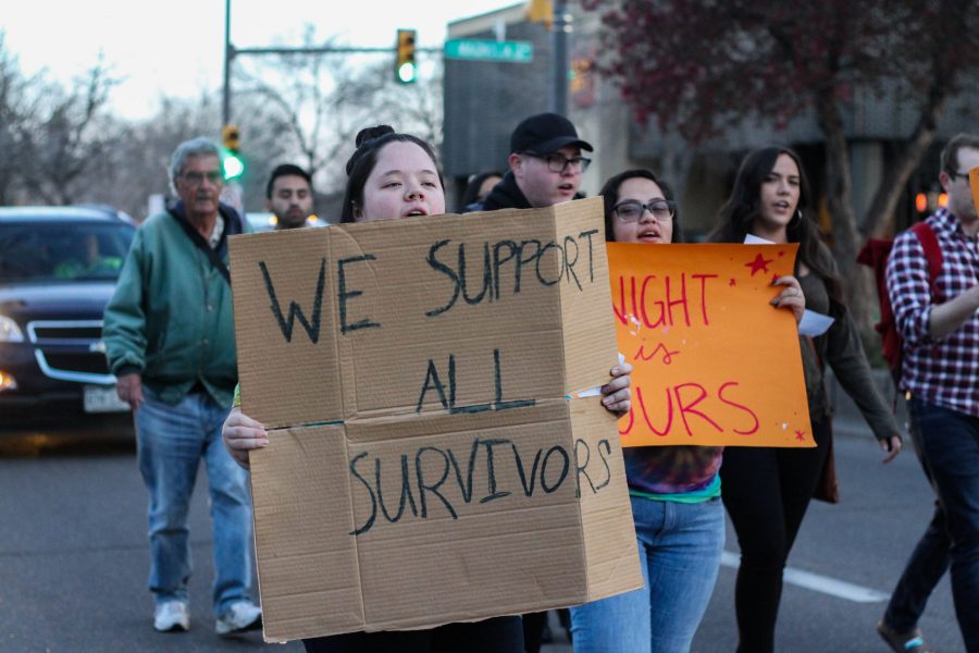 Participants of Take Back the Night march through the streets of Old Town with signs expressing messages of solidarity with survivors of sexual assault and domestic violence. (Ashley Potts | Collegian)