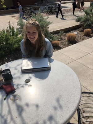 A student sits at a table outside Eddy Hall at Colorado State University