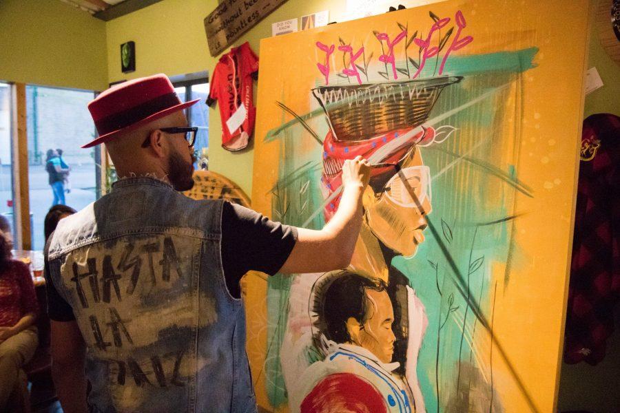 Armando Silva, a Greeley based Latino artist, live paints a portrait of what he hears from the five Latina womens stories at FoCo Speaks Ciencia! All of the money raised at the event went to CienciaPR, a Puerto Rican non-profit that encourages young women to pursue science (Julia Trowbridge | Collegian)
