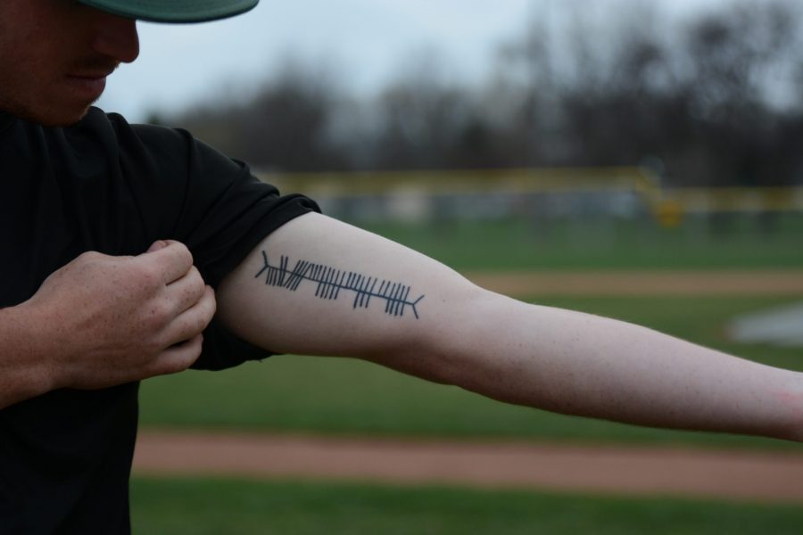 CSU Rams baseball pitcher, Phelan Castellano, shows off his Medieval Celtic language, Ogham, tattoo at an April 24 practice. (Mackenzie Boltz | Collegian)
