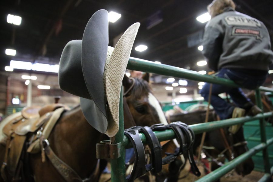 Cowboy hats hang on a railing behind the area gates at the 68th annual Skyline Stampede rodeo on April 7, 2018 at the B.W. Pickett Arena in Fort Collins.  (Forrest Czarnecki | The Collegian)