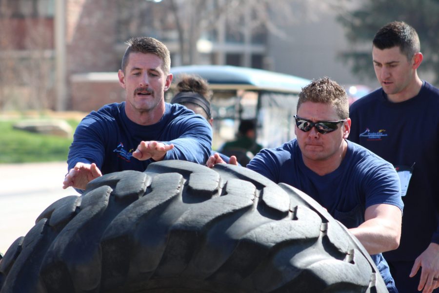 Team Poudre Fire Authority completes in the tire flip obstacle at Operation Bear Hug. (Megan Daly | Collegian)