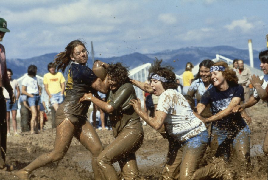 Students participate in the 1983 College Days Mud Bowl, where the intramural fields were transformed into a sea of water and mud for students to drink and play football in. (Photo courtesy of University Historic Photograph Collection ) 
