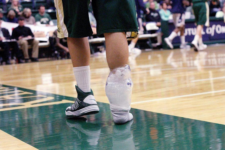 A CSU basketball player walks on the court with an ice pack taped to his ankle during a game in 2013. (Collegian file photo)