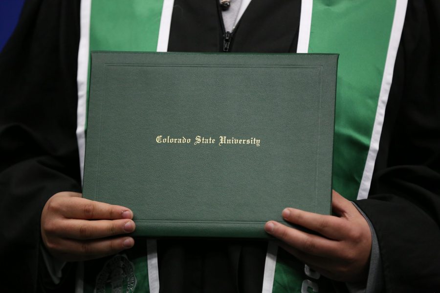 A Colorado State University graduate shows off their diploma during the graduation ceremony for the College of Agricultural Sciences on May 12, 2018 at Moby Arena.  (Forrest Czarnecki | The Collegian)