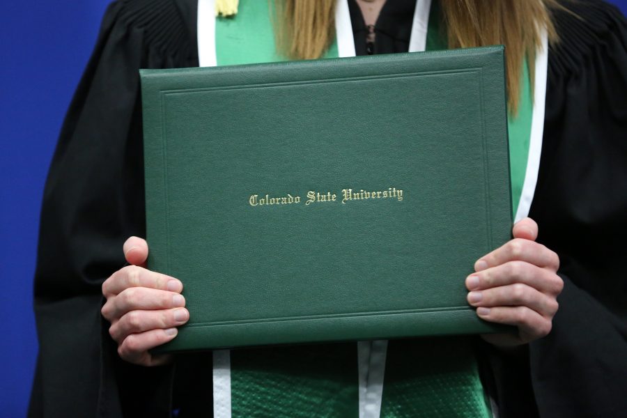A Colorado State University graduate shows off their diploma during the graduation ceremony for the College of Agricultural Sciences May 12, 2018 at Moby Arena.  (Collegian File Photo)