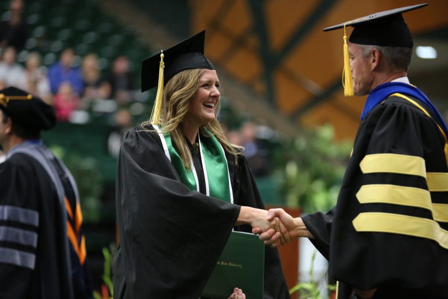 A Colorado State University graduate shakes the hand of a professor from the animal sciences department during the graduation ceremony for the College of Agricultural Sciences on May 12, 2018 at Moby Arena.  (Forrest Czarnecki | The Collegian)