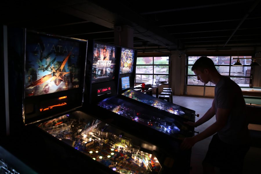 Elliott Layne plays a game of pinball at the Pinball Jones Campus West location during the last night of the summer league.  (Forrest Czarnecki | The Collegian)