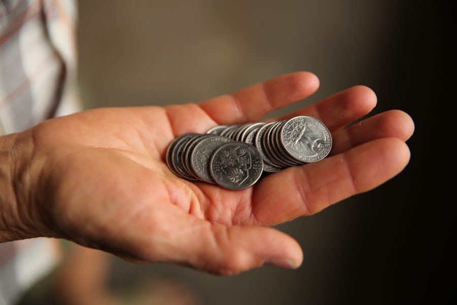 Kim Jones, a partner owner of the Pinball Jones Campus West location holds out a handful of quarters as she prepares to play a few games of pinball.  (Forrest Czarnecki | The Collegian)