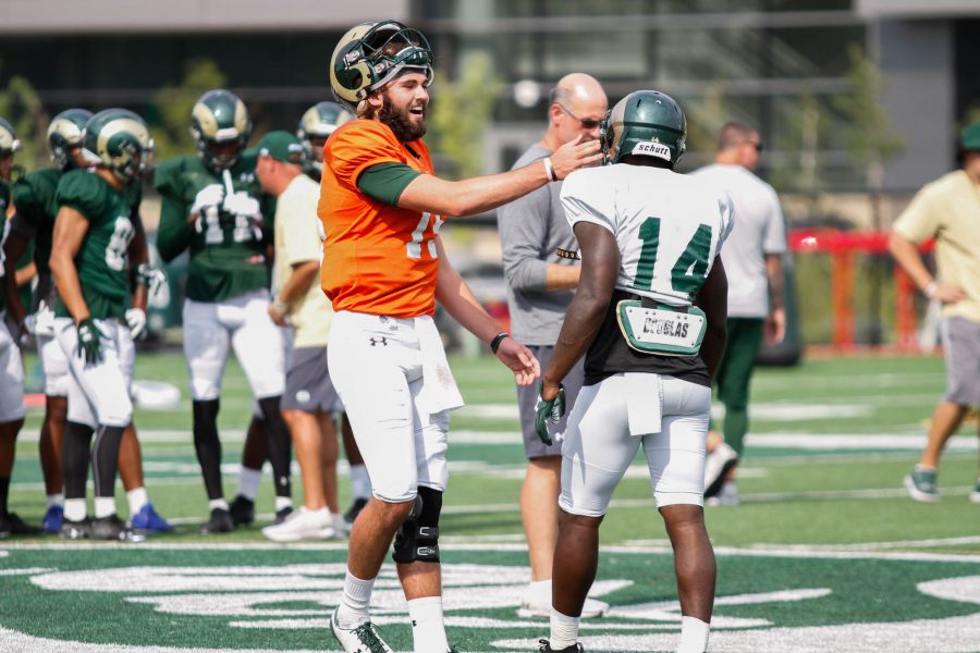 Collin Hill jokes around with Anthony Hawkins in between drills at practice on August 2. (Ashley Potts | Collegian)