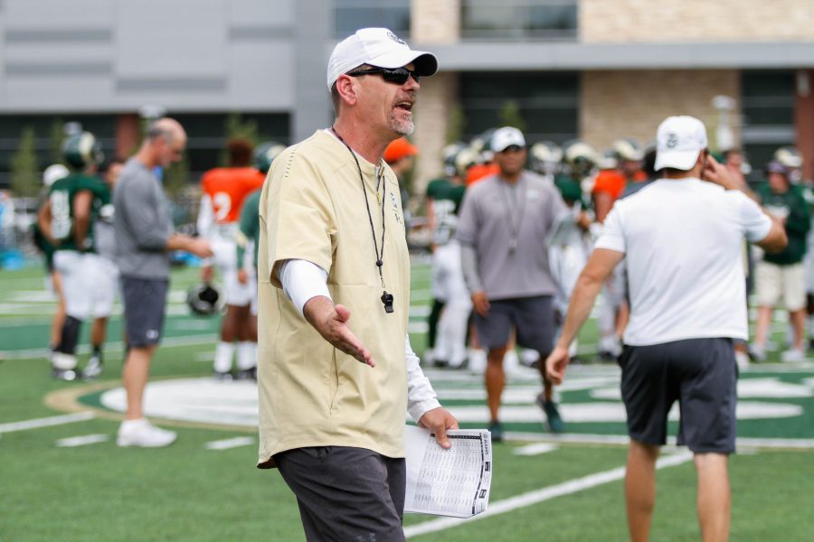 Coach Mike Bobo high fives a player during a drill at practice on August 2. (Ashley Potts | Collegian)