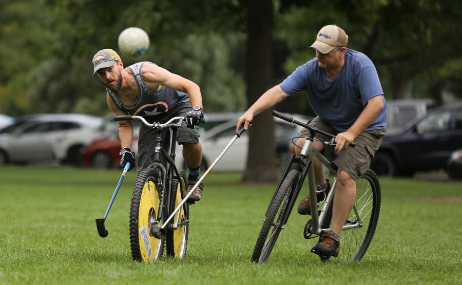 Tom Propst, left, makes his game-winning shot while Eric Peterson, right, defends against him during a game of bike polo at City Park on Aug. 26.  (Forrest Czarnecki | The Collegian)