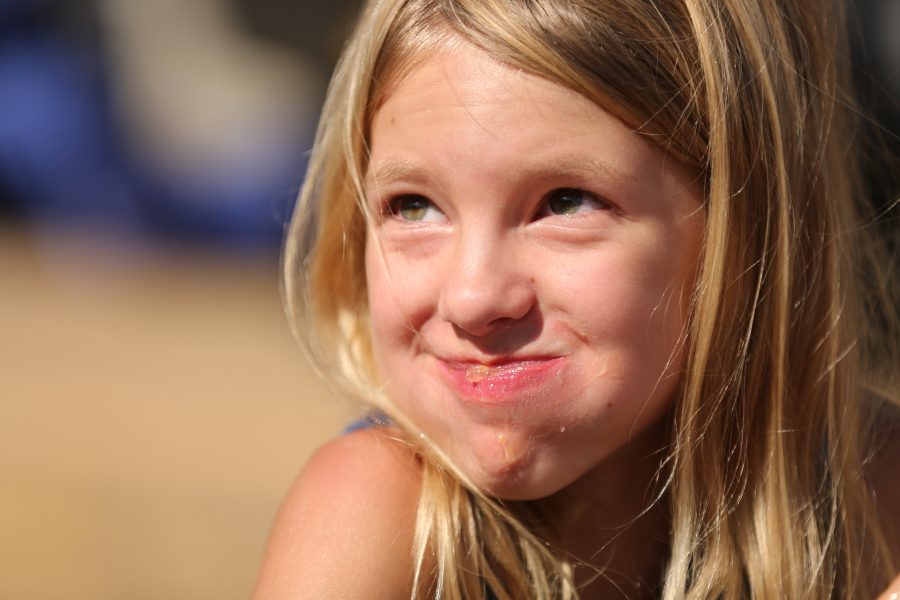 Jayna Jamison flashes a smile toward her mom after competing in the peach pie eating contest at the 2018 Fort Collins Peach Festival on Aug. 18.  (Forrest Czarnecki | The Collegian)