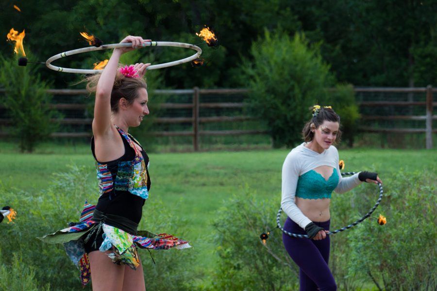 Corinne Watson, doing business as CoCo Hula Hoop Extraordinaire (left) hula hoops during the fairy act. She is the producer of A Midsummer Nights Fire Circus and owner of Spectra Circus Entertainment. She has been hula hooping since 2009 and differentiates herself professionally by adding fire to her hula hoop acts.  (Sara Graydon | Collegian)