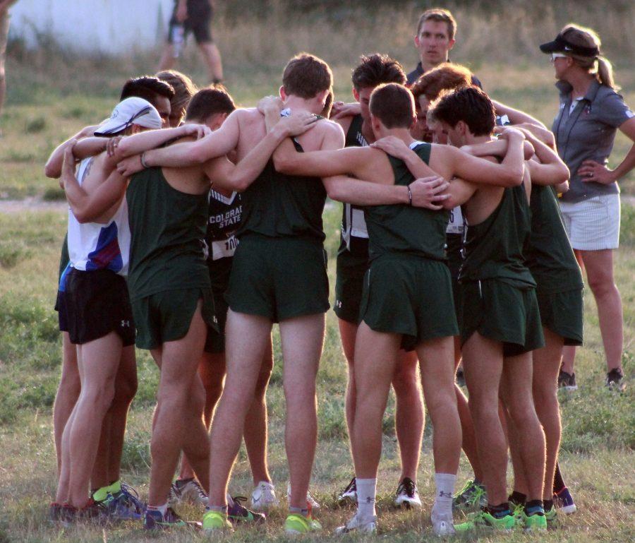 The men's cross country gathers in a huddle before their meet at Hughes Stadium on Sept 1. (Megan Daly | Collegian)