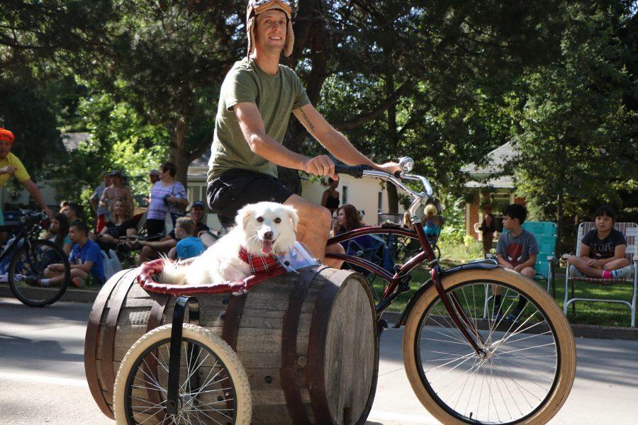 A dog and his owner smile for the camera as they pass by during the parade. (Devin Cornelius | Collegian)