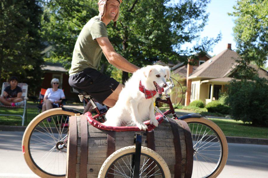 A dog and his owner smile for the camera as they pass by during the parade. (Devin Cornelius | Collegian)