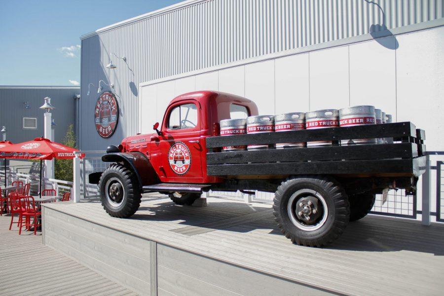 One of many red trucks is displayed in an outside seating area at Red Truck Beer Company. (Ashley Potts | Collegian)