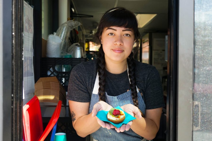 Employee Hailey Moy serves a donut through the order window. . (Collegian | Lauryn Bolz)
