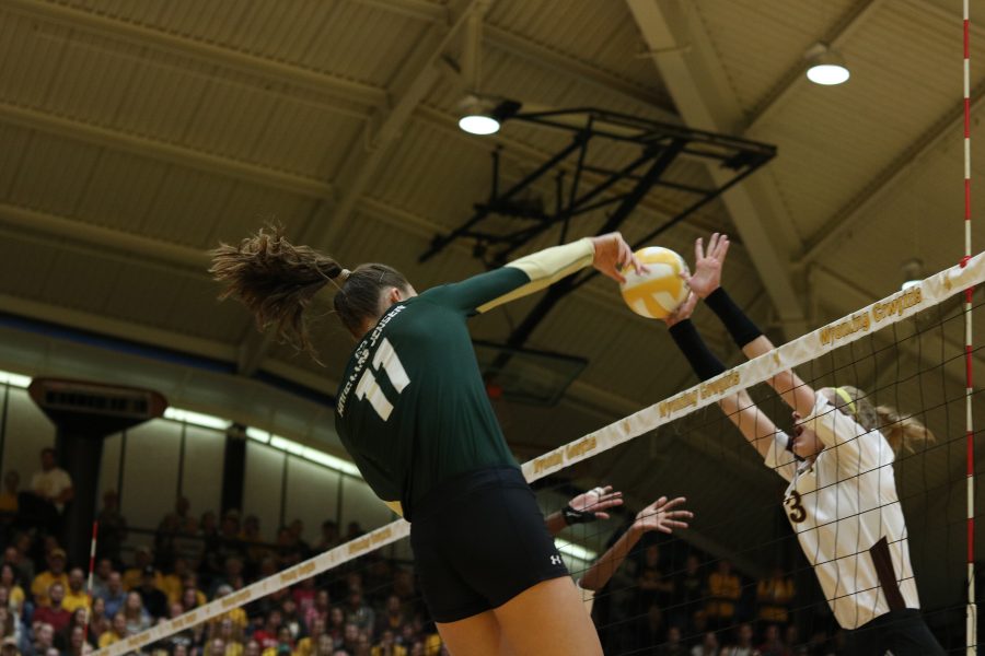 Paulina Hougaard-Jensen spikes the ball off of a Wyoming player (Devin Cornelius | Collegian)