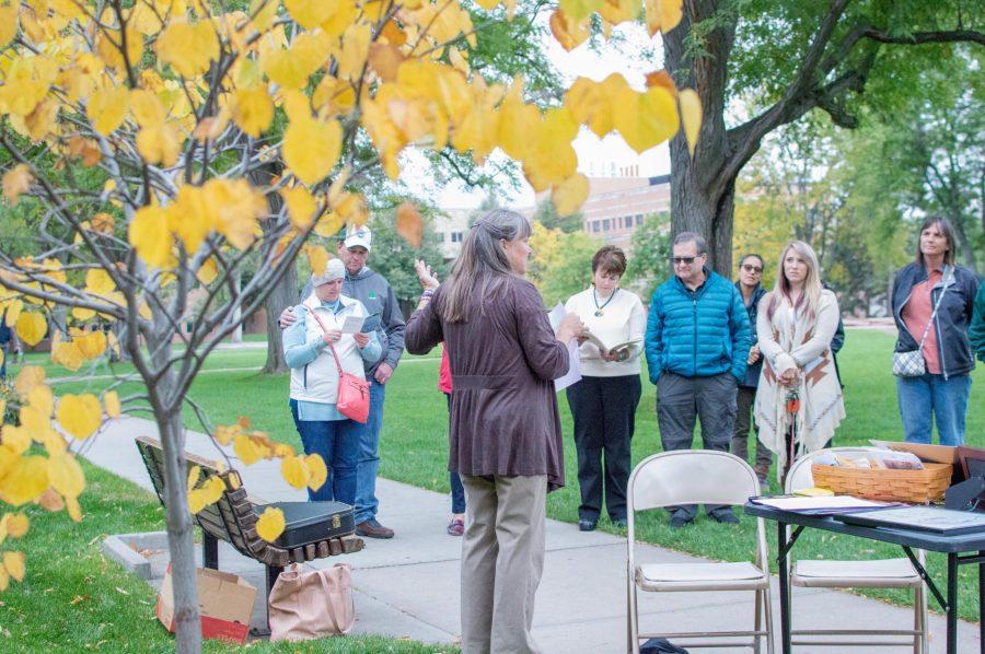 Anne Fenwick tells a story about her late husband, Professor Jack Fenwick, in front of the tree planted in his memoriam behind the Plant Sciences building. (AJ Frankson | Collegian)