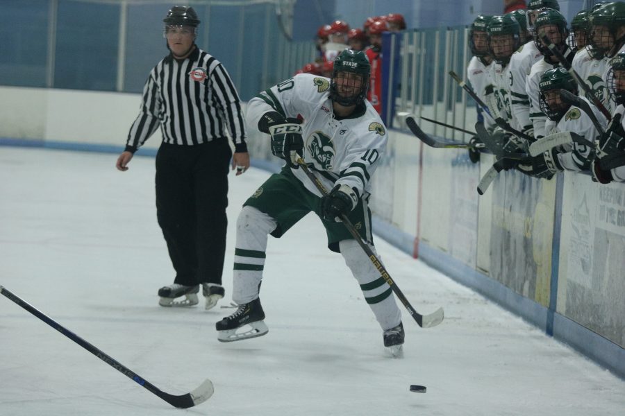 Greyson North (10) passes the puck to another CSU player as the bench watches on delight. (Devin Cornelius | Collegian)