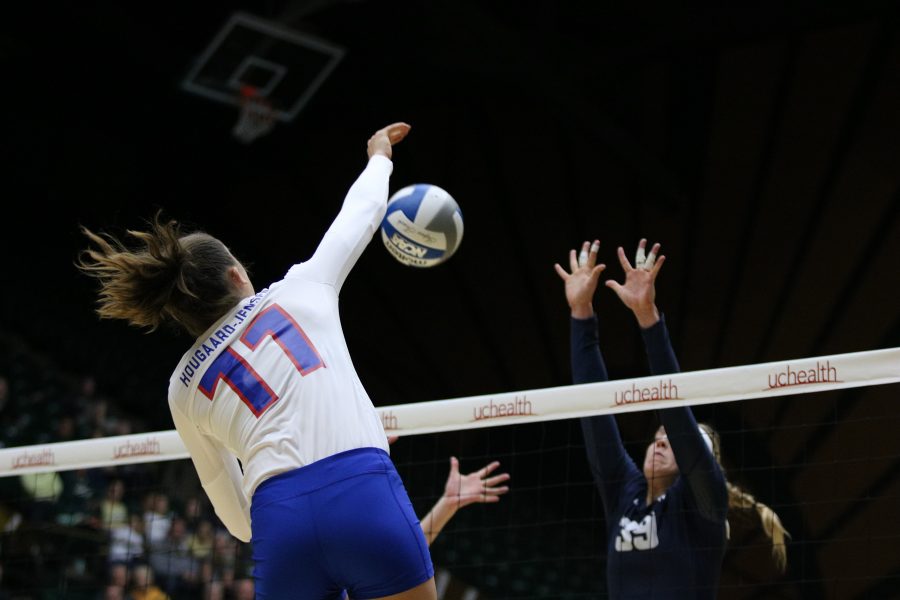 Paulina Hougaard- Jensen(11) spikes the ball down onto the Utah State defense for a point (Devin Cornelius | Collegian)]