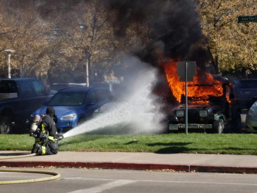A fireman douses a Jeep burning in the Administration Building parking lot October 22nd. (Davis Bonner | Collegian)