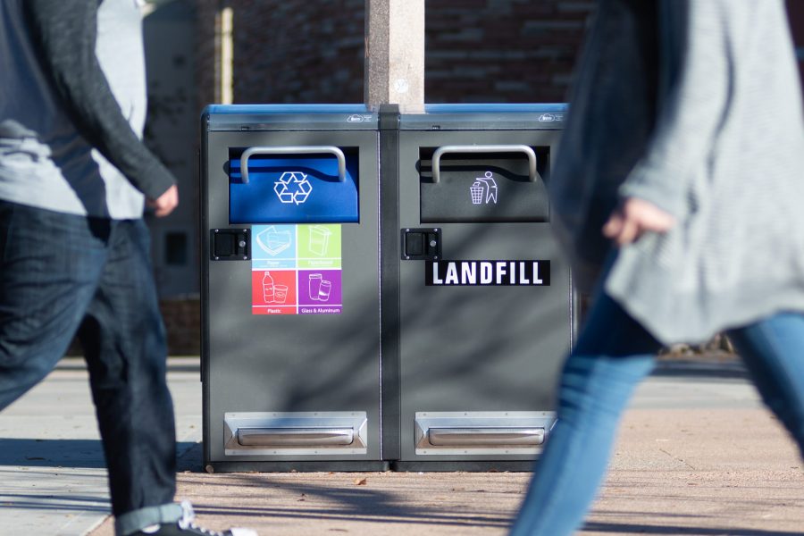 Students walk in front of the solar-powered trash and recycling bins in the Plaza. The bins were introduced to campus in late September. (Photo Illustration by Colin Shepherd | Collegian)